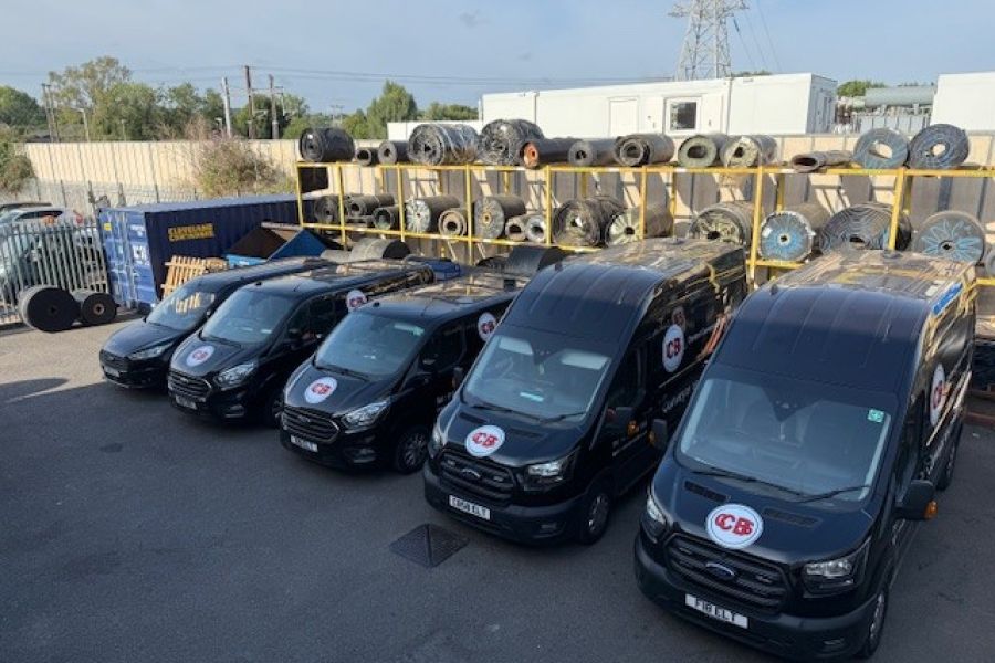 CCBS Vans in the yard with Conveyor Belting on racks